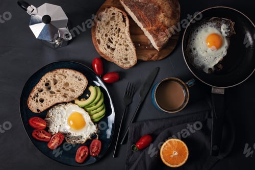 Preview: Breakfast served with coffee, bread, fried eggs, avocado and tomatoes
