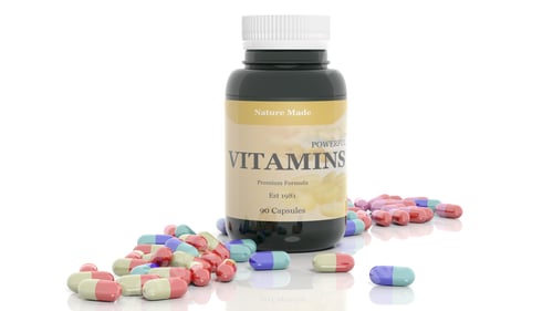 Preview: Colorful caplets vitamins and bottle, isolated on white background.