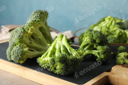 Preview: Board with broccoli on grey table, close up. Healthy food