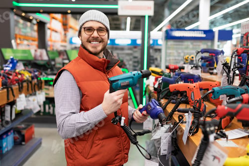 Preview: a satisfied customer purchases an electric drill and screwdriver in an electrical and construction