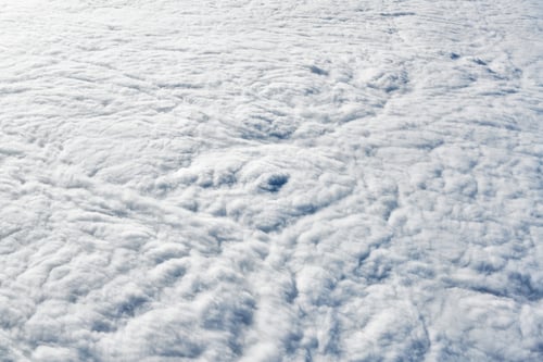 Preview: Over clouds top view from aircraft window, thick white blue clouds looks like soft foam