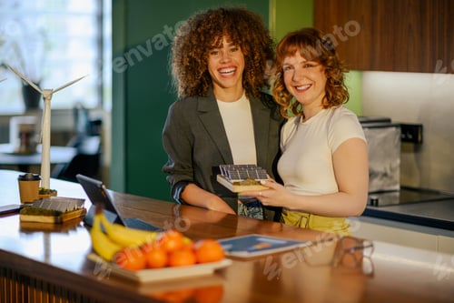 Preview: Happy environmentalists with solar panels model at modern office.