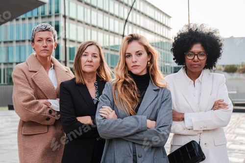 Preview: Real executive businesswomen looking at camera with serious and proud expression at downtown