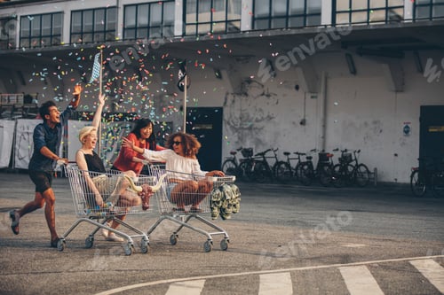 Preview: Multiethnic young people racing with shopping trolleys