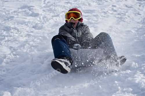 Preview: Little boy in the ski glasses have fun on sleds and descend from the snow slide