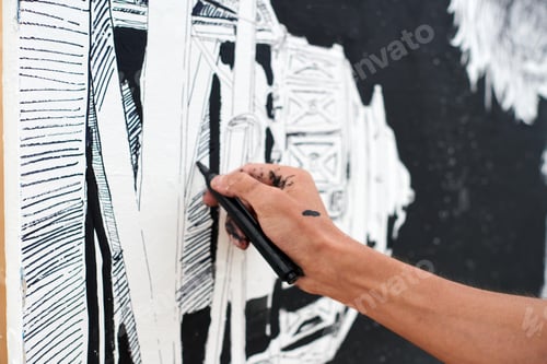 Preview: Young male painter passionately paints picture with black permanent marker for street exhibition