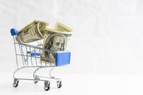 Preview: A small shopping cart with 100 dollar bills on a table with space for text.