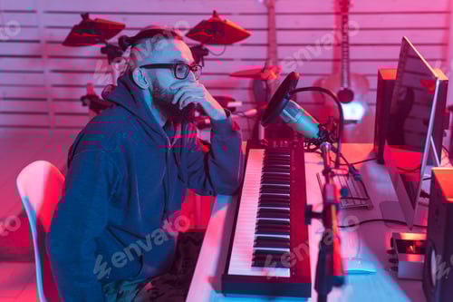 Visualização: Músico profissional gravando sintetizador em estúdio digital em casa, tecnologia de produção musical