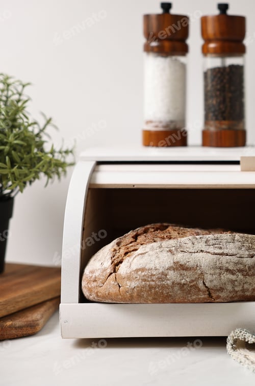 Preview: Wooden bread basket with freshly baked loaves on white marble table in kitchen