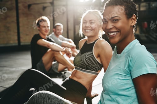 Preview: Two laughing young women sitting together at the gym