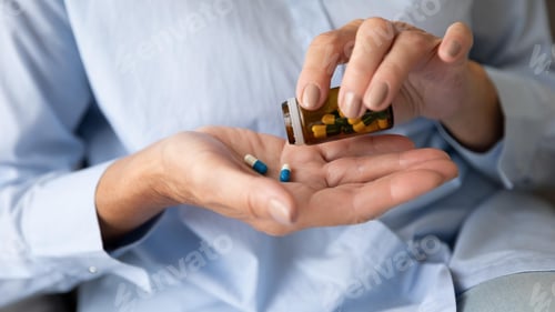 Preview: Hands Pouring Pills from Bottle into Palm