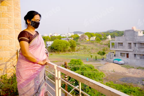 Preview: Woman standing at balcony wearing medical protective masks.