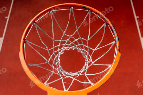 Preview: Close-up of basketball ring into which a tall guy basketball player throws the ball from below