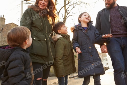 Preview: Mid adult couple and three children strolling on street