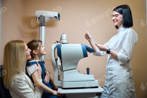 Preview: Mother and her little daughter are sitting at an autorefractometer