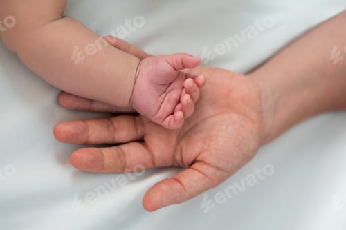 Preview: Close up mother holding hands newborn boy in a room with a lot of sunlight. Baby