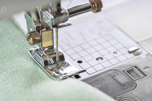 Preview: Modern Sewing Machine Presser Foot With Green Fabric And Thread, Closeup, Macro