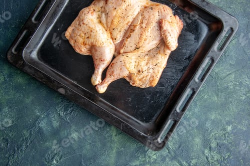 Preview: top view fresh spiced chicken on bake pan on dark-blue background food spice pepper baking dish