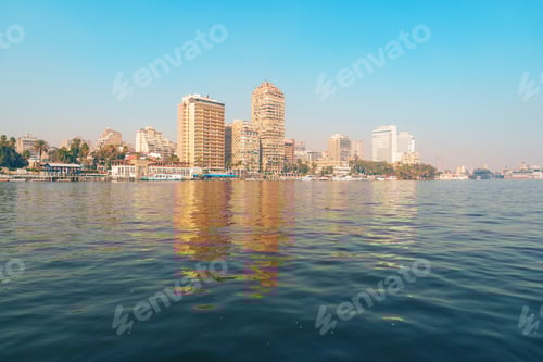 Preview: Stunning skyline view of Cairo with blue waters reflecting towering buildings on a clear sunny day