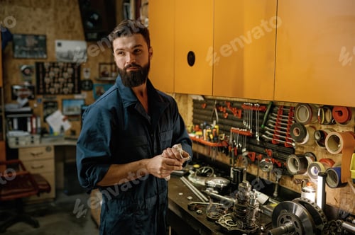 Preview: Portrait of serviceman looking aside standing over garage workshop interior