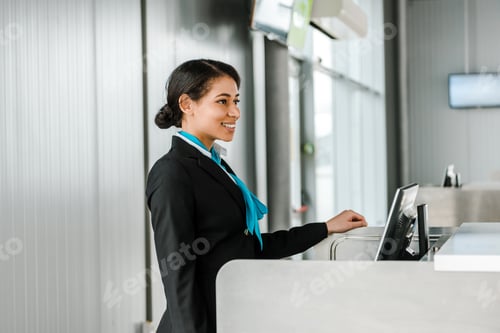Preview: cheerful african american airport staff in uniform standing at workplace