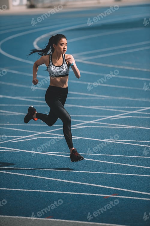 Preview: Athletic young sportswoman sprinting on running track stadium
