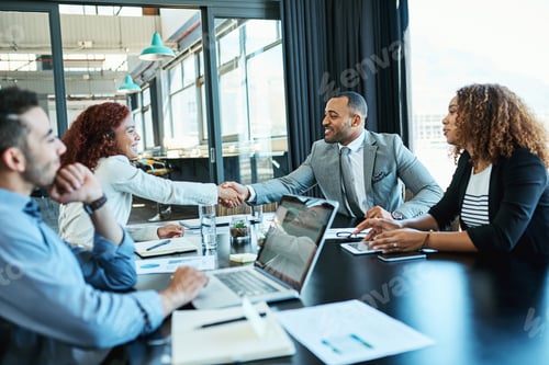 Preview: Shot of businesspeople shaking hands during a meeting in an office