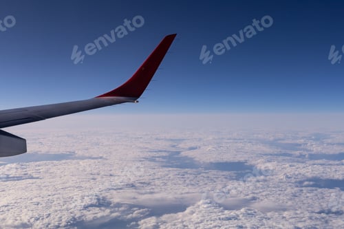 Preview: the wing of a flying aircraft against the background of clouds