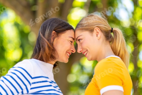 Preview: Close up smiling mother daughter face to face in park