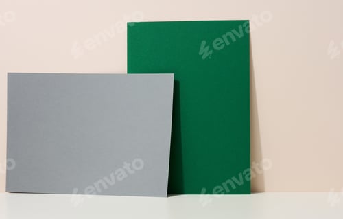 Preview: Blank green and gray cardboard sheet of paper with shadow on white table