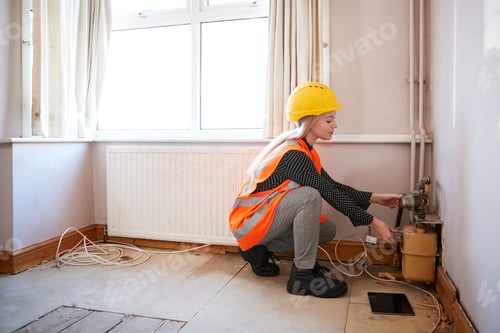 Preview: Female Surveyor In Hard Hat And High Visibility Jacket Checking Gas Supply