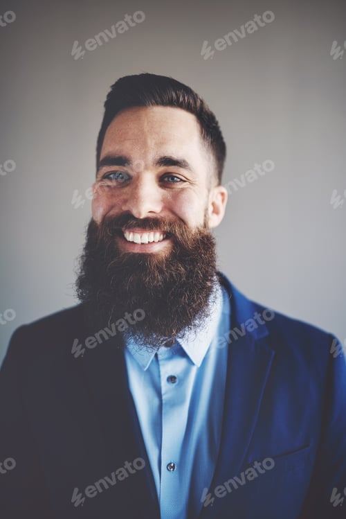 Preview: Smiling young entrepreneur with a long beard wearing a blazer