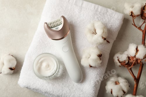 Preview: Towel, epilator, cotton and cream on white background