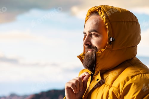 Preview: Determined climber standing at the summit enjoys peaceful moment