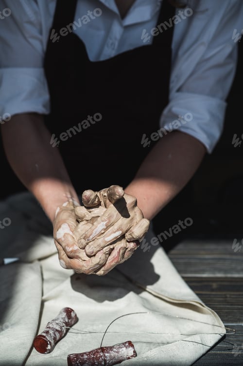 Preview: A young potter woman making pot in her own working place. Standing in spacious studio creating the