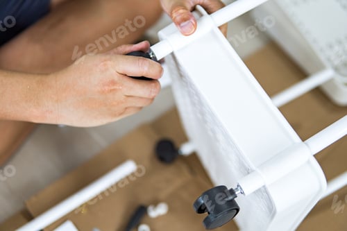 Preview: Man assembles household items.