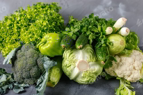 Preview: Variety of raw green vegetables on grey background. Copy space