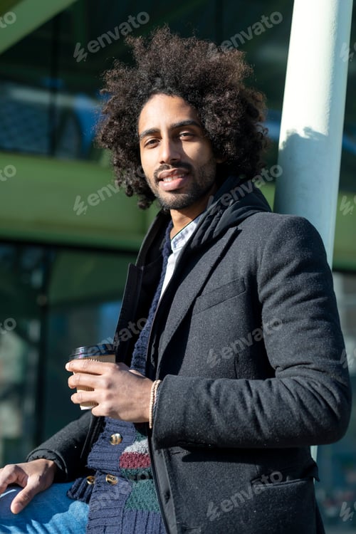 Preview: african american man with beard standing at the street drinking a take away cup of coffee