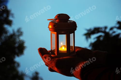 Preview: Woman holding Christmas lantern with burning candle in evening, closeup