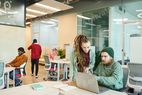 Preview: Two young contemporary office managers in casualwear looking at laptop display