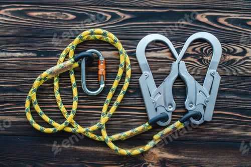 Preview: Isolated photo of climbing equipment. Parts of carabiners lying on the wooden table