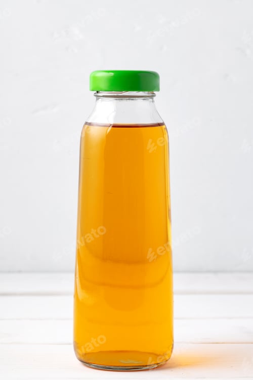 Preview: Small glass bottle of fresh juice on white background