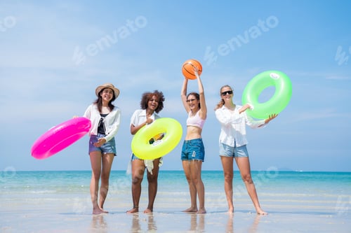 Preview: roup of teenage with floaty on the beach having fun in a sunny day