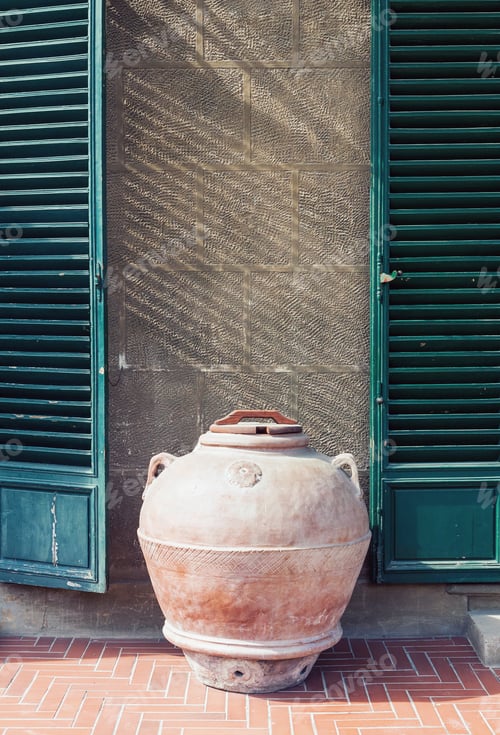 Preview: Antique clay jar standing by the wall of an old house in Italy