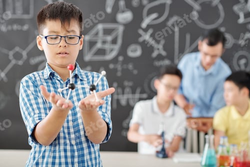Preview: Schoolboy looking at plastic model