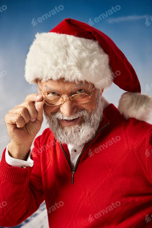 Preview: Merry Christmas, cheerful Santa in hat touching his glasses and smiling sincerely at camera