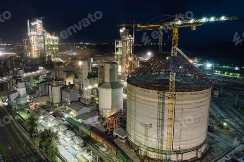 Preview: Aerial view of cement factory with high concrete plant structure and tower cranes at industrial