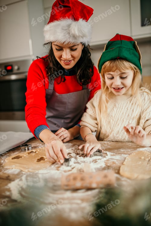 Preview: Mother daughter baking christmas cookies in kitchen