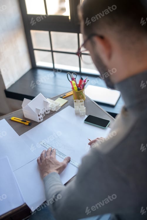 Preview: Top view of designer drawing sketches lying near phone