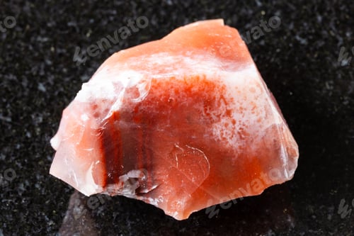 Preview: sample of raw carnelian mineral on black granite